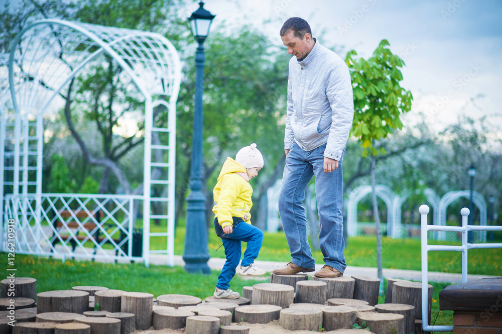 Dad and his daughter are playing in the beautiful park