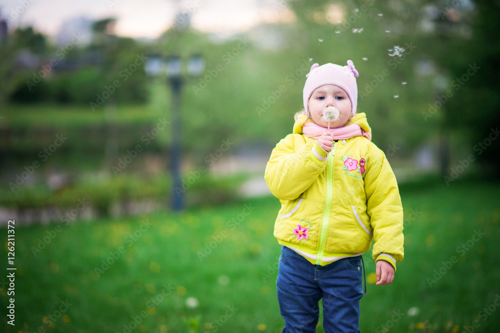 Funny baby girl in a yellow coat and pink hat Funny baby girl in a yellow coat and pink hat
