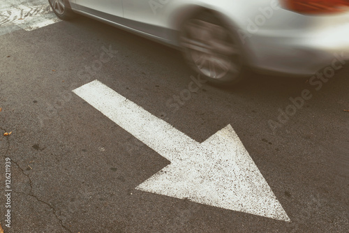 Driving car in wrong direction against traffic arrow sign photo