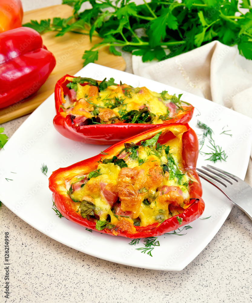 Pepper stuffed with sausage and cheese in white plate on stone t Pepper stuffed with sausage and cheese in white plate on stone t