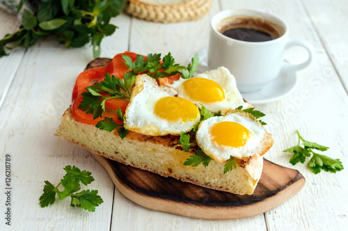 Bruschetta with quail egg, bell pepper, herbs and a cup of coffee. Light breakfast.