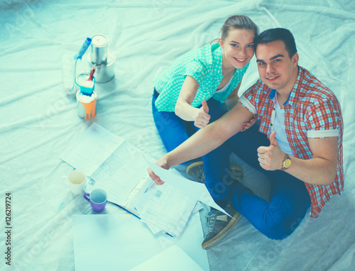 Young couple sitting on floor and calculating about they savings