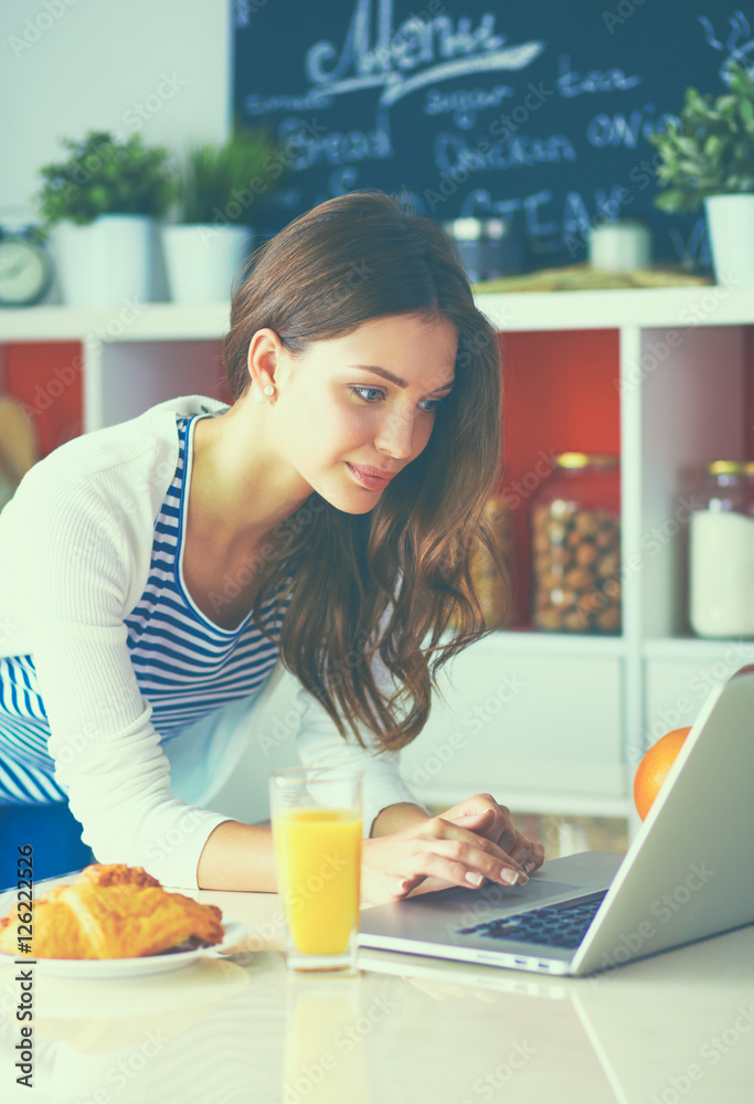 Young woman sitting near desk in the kitchen