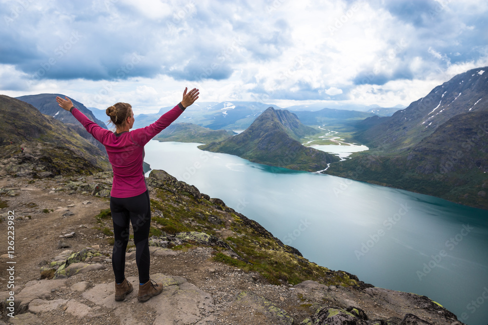 Sport woman hiking on Besseggen. Hikers enjoy beautiful lake and good weather in Norway. Sport woman hiking on Besseggen. Hikers enjoy beautiful lake and good weather in Norway.