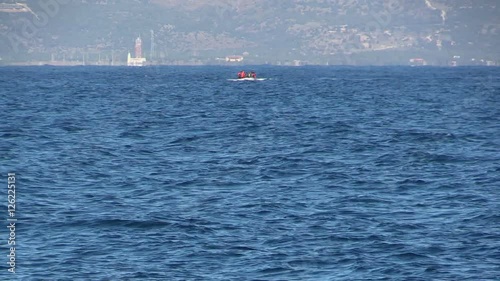 LESVOS, GREECE - NOV 2, 2015: Refugees in a rubber dinghy swim to shore from Turkey.
