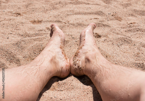 feet in the sand on the beach