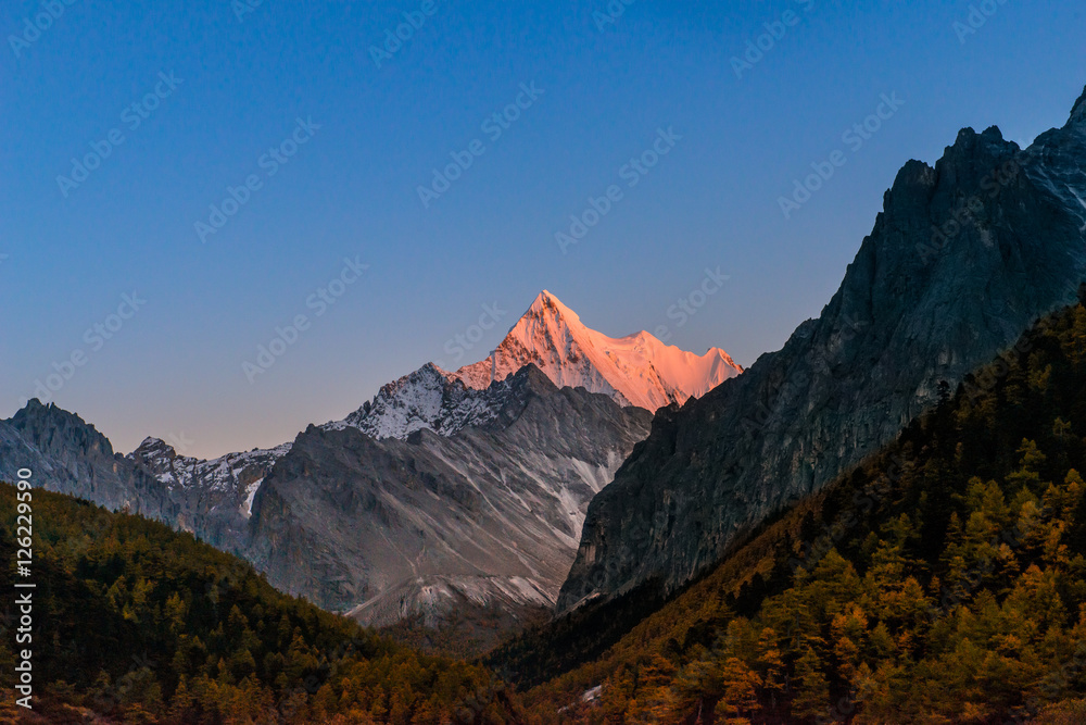 Sunset view of The Holy Snow mountain in Yading national reserve at Daocheng County, in the southwest of Sichuan Province, China.