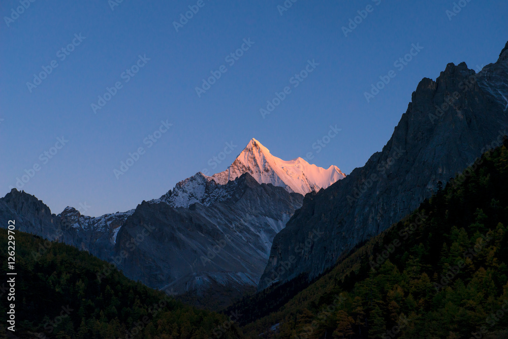 Sunset view of The Holy Snow mountain in Yading national reserve at Daocheng County, in the southwest of Sichuan Province, China.