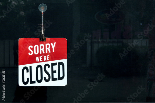 Closed sign in a shop window sorry we are closed. photo