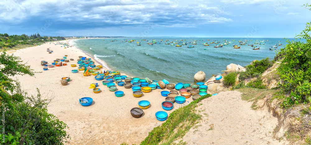 Binh Thuan, Vietnam - July 26th, 2016: Ganh Son Beach on  sunny afternoon with many basket boats lined beach, this is beautiful coastline attract tourists to visit in Binh Thuan, Vietnam