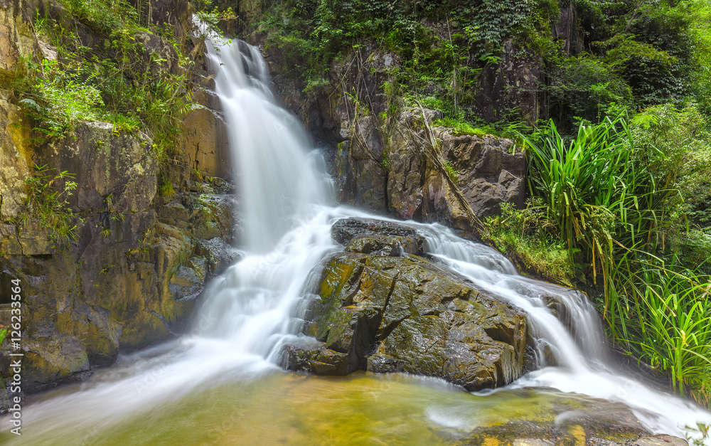 Landscape waterfall flowing into soft silk sheet in the forest create the beauty of the natural world in the wilderness. Landscape waterfall flowing into soft silk sheet in the forest create the beauty of the natural world in the wilderness.