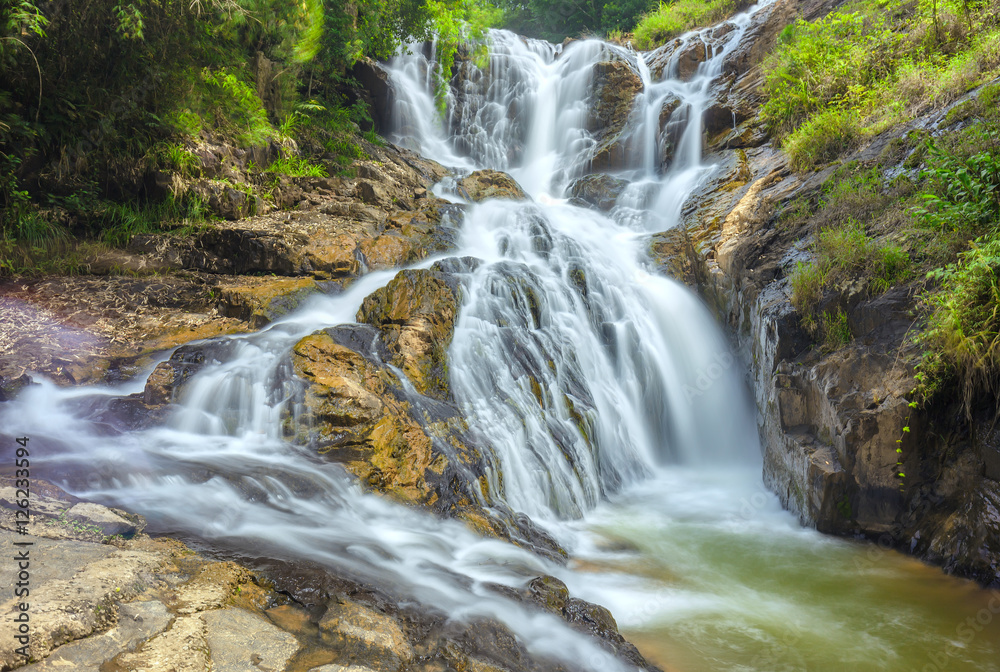 Landscape waterfall flowing into soft silk sheet in the forest create the beauty of the natural world in the wilderness. Landscape waterfall flowing into soft silk sheet in the forest create the beauty of the natural world in the wilderness.