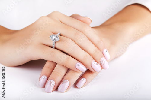Obraz na płótnie Close up hands of young woman with engagement ring with a diamond. Close up of elegant diamond ring. Close up of elegant diamond ring on the finger. Diamond ring. w salonie