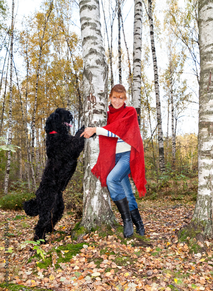 Young attractive woman in a red poncho and a dog Russian Black T Young attractive woman in a red poncho and a dog Russian Black T