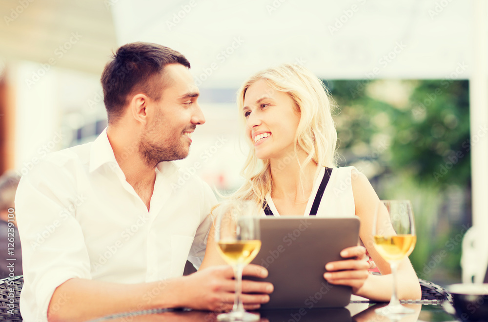 happy couple with tablet pc at restaurant lounge happy couple with tablet pc at restaurant lounge