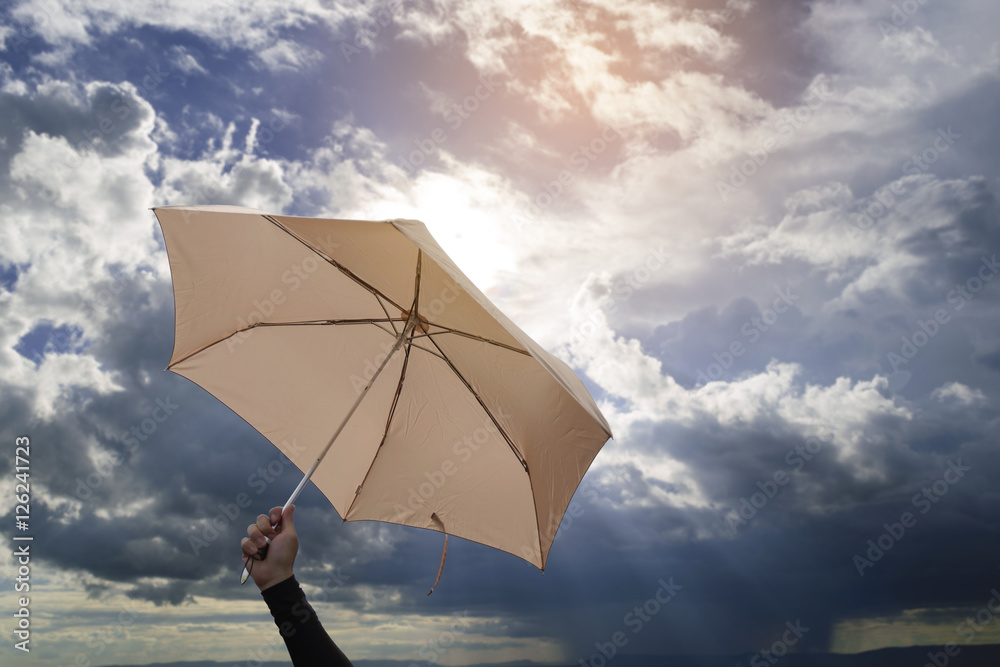 Hand holding umbrella with blue sky and sunlight background. Hand holding umbrella with blue sky and sunlight background.