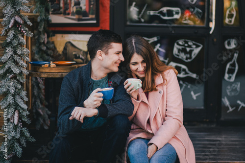 Happy couple in warm clothes drinking coffee on a Christmas market. Holiday mood
