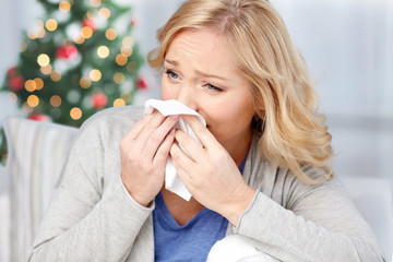 ill woman blowing nose to paper napkin