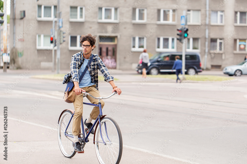 Fototapeta premium young hipster man with bag riding fixed gear bike