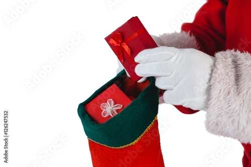 Santa Claus putting presents in Christmas stockings