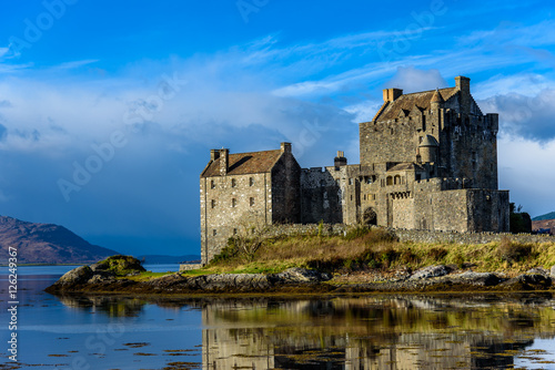 Majestic Eilean Donan castle on beautiful autumn day - with sunny foreground, dramatic sky and amazing scenery