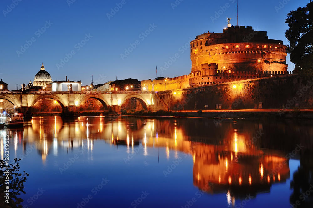 Rome, Italy - Mausoleum of Hadrian and river Tiber at night, on background St. Peter's Basilica dome