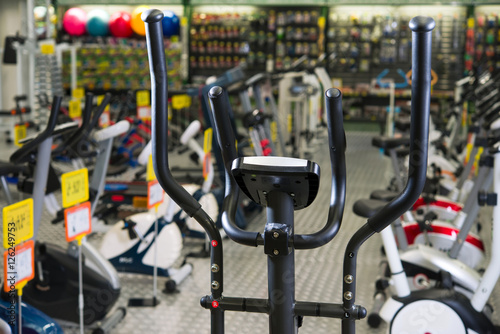 Store selling sports goods. Treadmills exercise machines stand in rows.