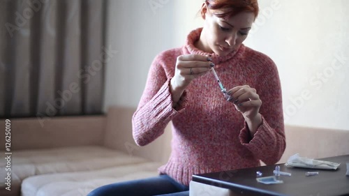 Woman picking up medication into a syringe