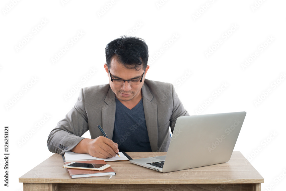 businessman writing notes on a writing pad while sitting at his businessman writing notes on a writing pad while sitting at his