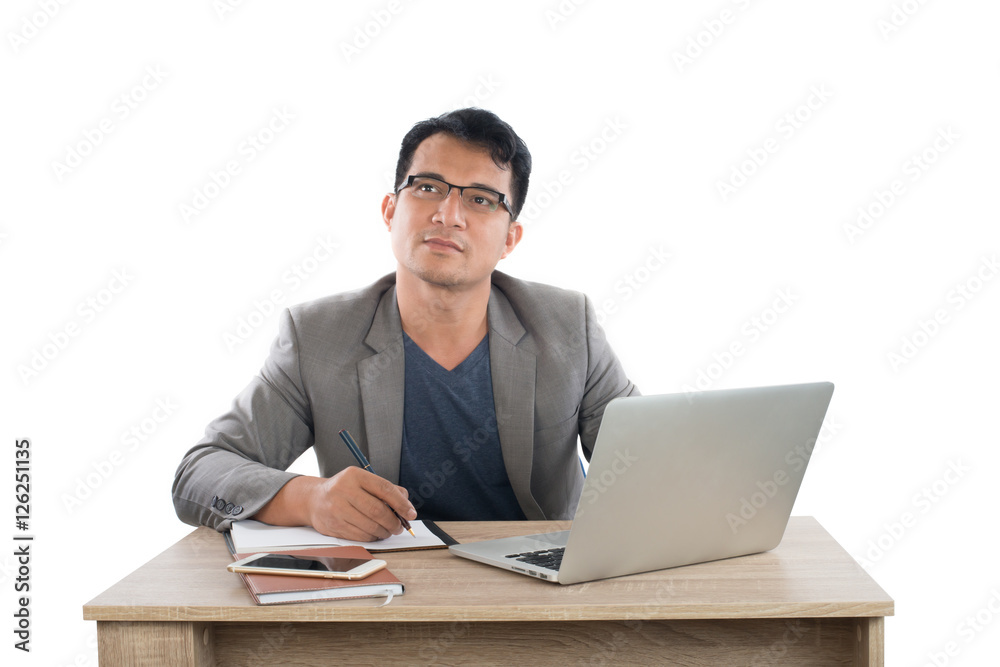businessman writing notes on a writing pad while sitting at his businessman writing notes on a writing pad while sitting at his