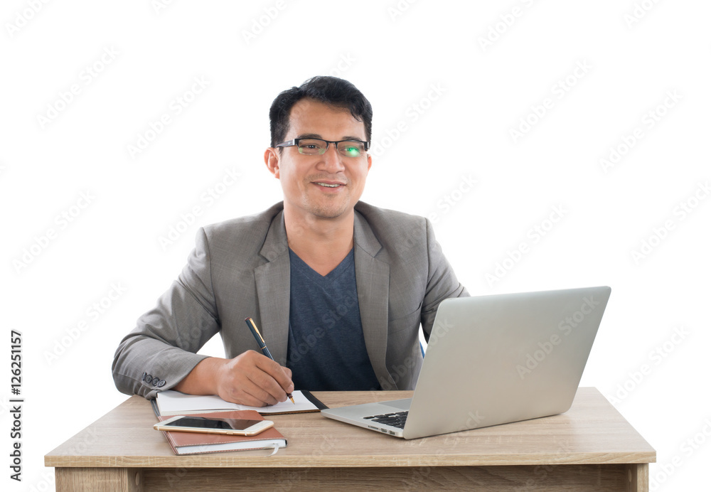 businessman writing notes on a writing pad while sitting at his businessman writing notes on a writing pad while sitting at his