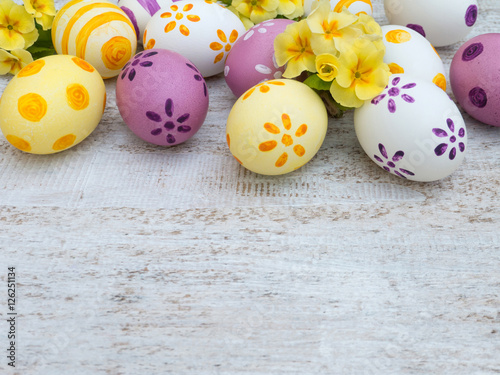 Easter eggs and primula flowers composition on the white wooden