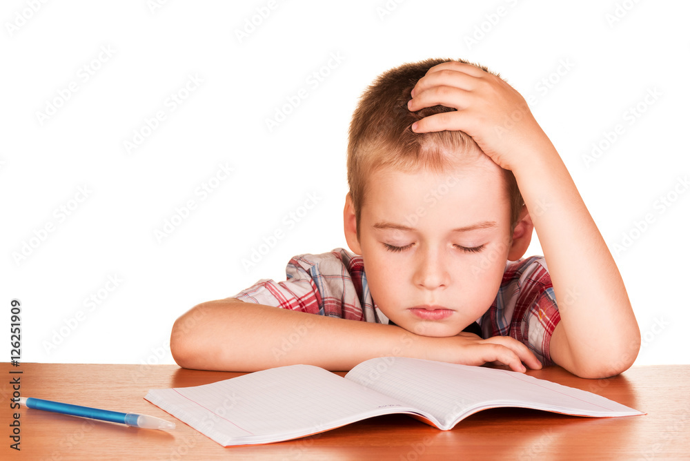 Boy sitting at table fell asleep on exercise book isolated. Boy sitting at table fell asleep on exercise book isolated.
