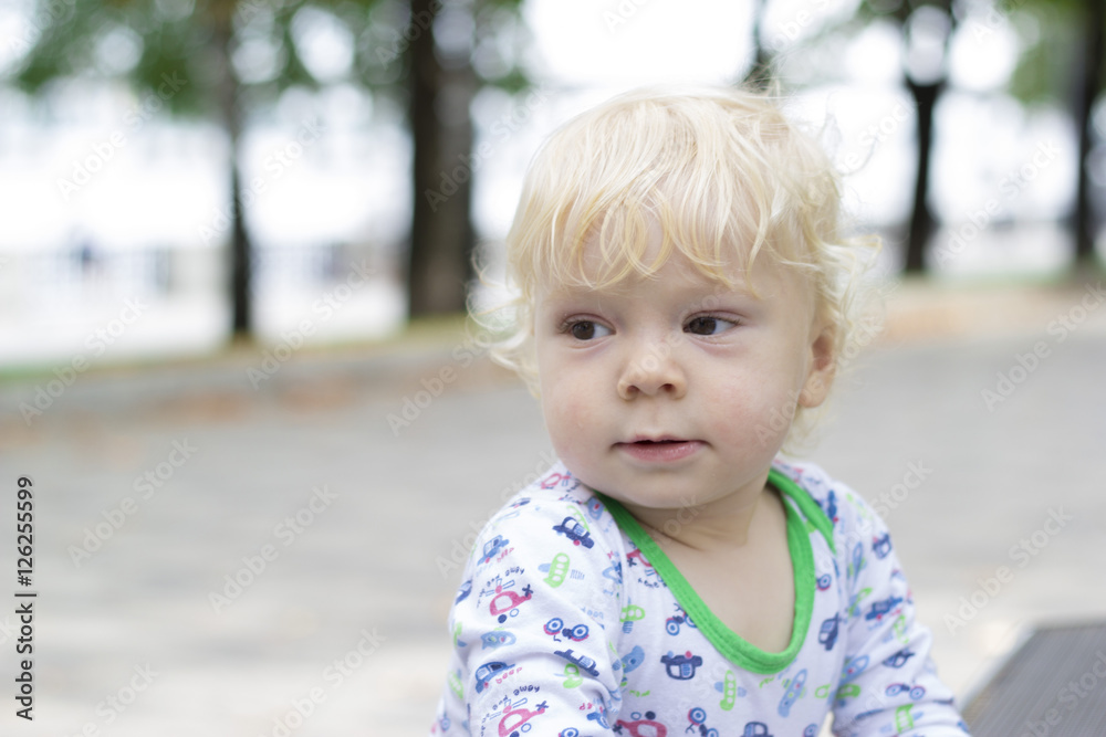 A small child learns to walk near the benches, toddler A small child learns to walk near the benches, toddler