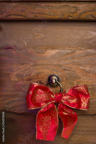 Red bow on wood background