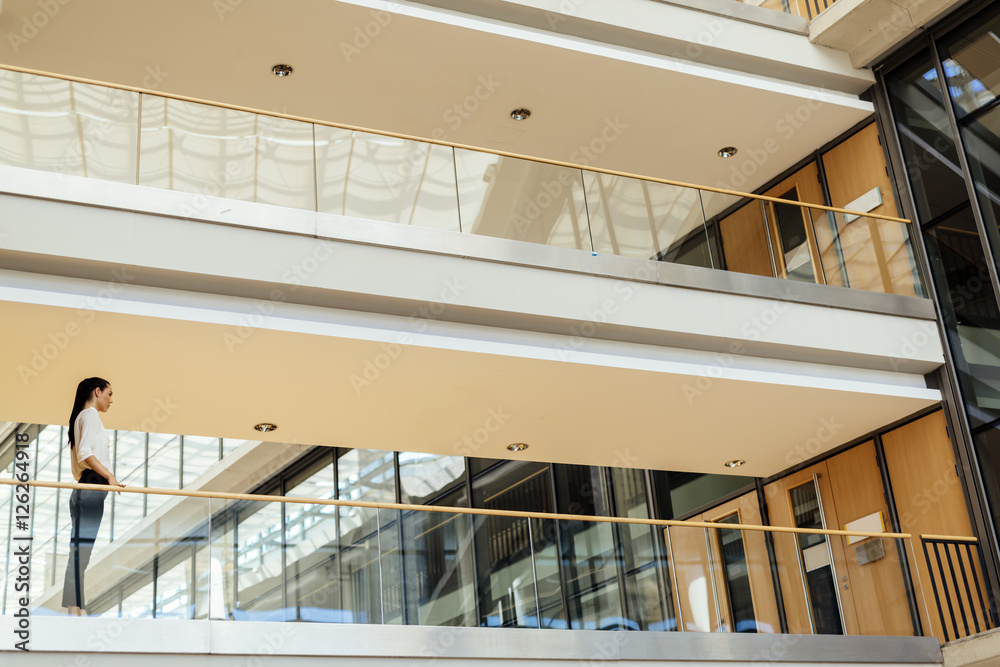 Fototapeta premium Elegant businesswoman walking inside building