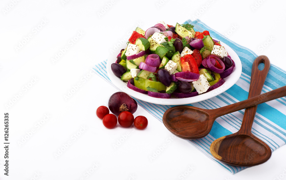 Φωτογραφία Fresh Greek salad with organic vegetables and feta cheese placed with wooden spoons on white background