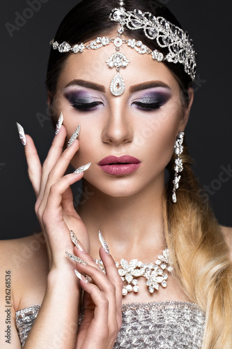 Beautiful girl in the image of the Arab bride with expensive jewelry  oriental make-up and bridal manicure. The beauty of the face. Photos shot in the studio.