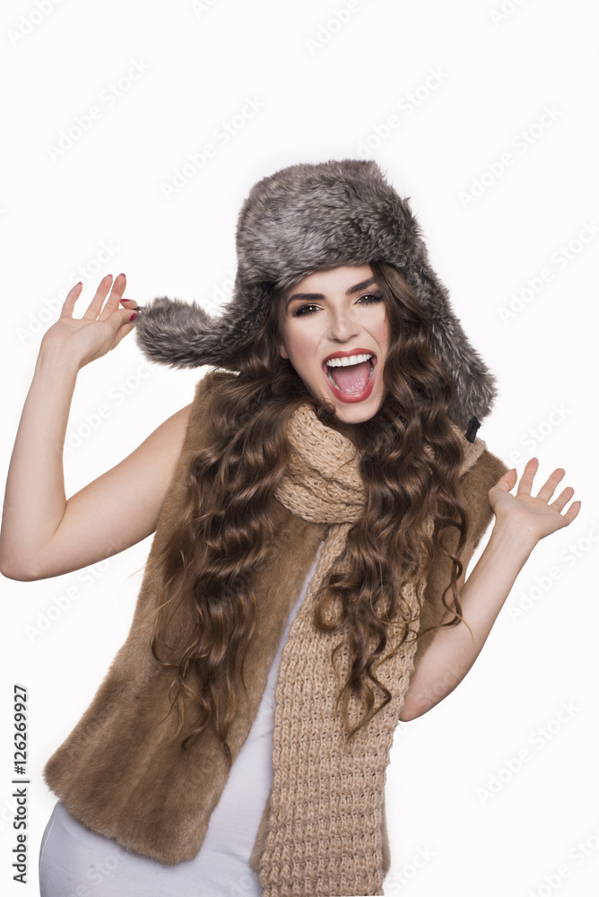 Surprised beautiful young woman with curly long brown hair standing with hand on winter hat and shouting. studio shot isolated on white background. Cheerful and crazy. Surprised beautiful young woman with curly long brown hair standing with hand on winter hat and shouting. studio shot isolated on white background. Cheerful and crazy.