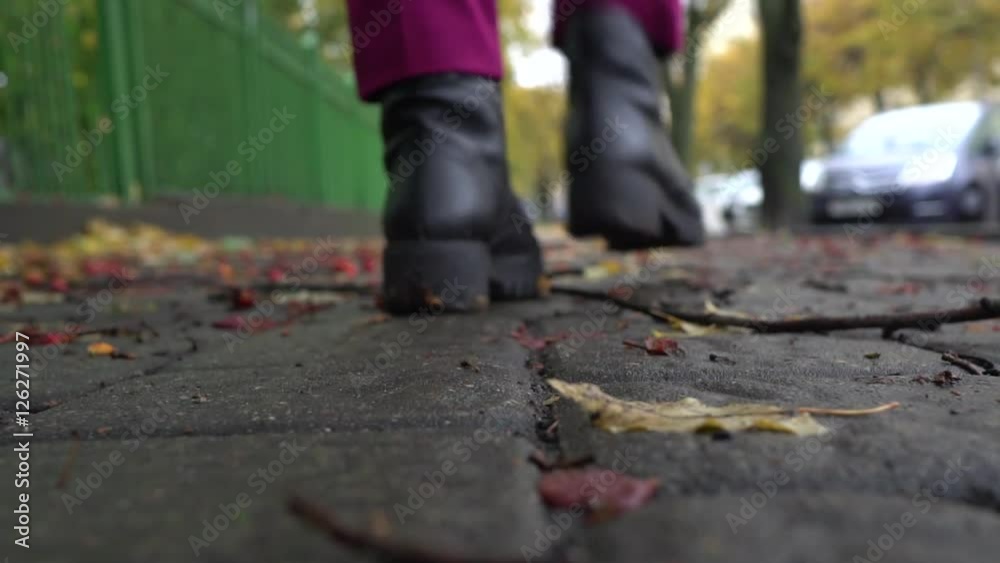 Slow motion. Autumn alley with fallen branches and leaves. Women walk going to her car Slow motion. Autumn alley with fallen branches and leaves. Women walk going to her car
