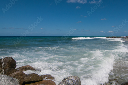 Mareggiata sulla costa, onde si infrangono sulla scogliera photo