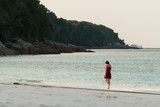 Girl by the beach in the evening with sea and sky at Tachai Island, Similan Islands National Park, Phang Nga, Thailand.