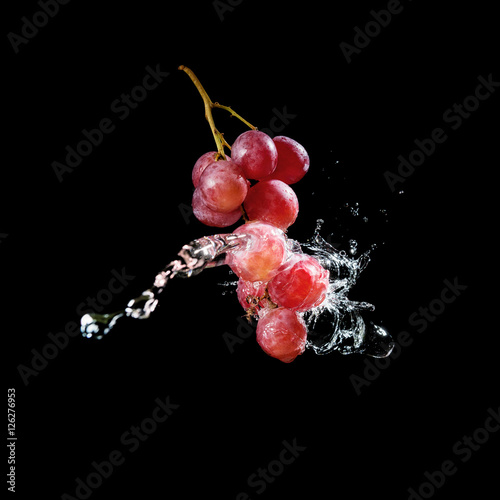 Bunch of grapes in water splash isolated on black background