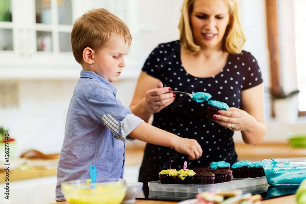 Fototapeta premium Child helping mother make cookies