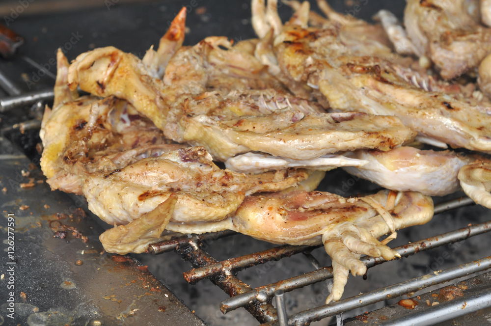 Chicken grilled over a charcoal fire Chicken grilled over a charcoal fire