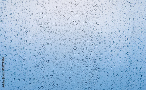 Graduated blue color of drop of rain water on glass