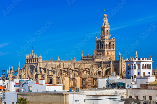 Famous Bell Tower named Giralda in landmark catholic Cathedral Saint Mary of the See, aerial view from the Torre Del Oro, Seville, Andalusia, Spain photo
