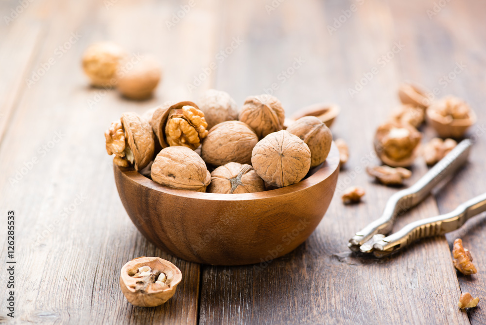 Walnuts in wooden bowl on table with Nutcracker. Walnuts in wooden bowl on table with Nutcracker.
