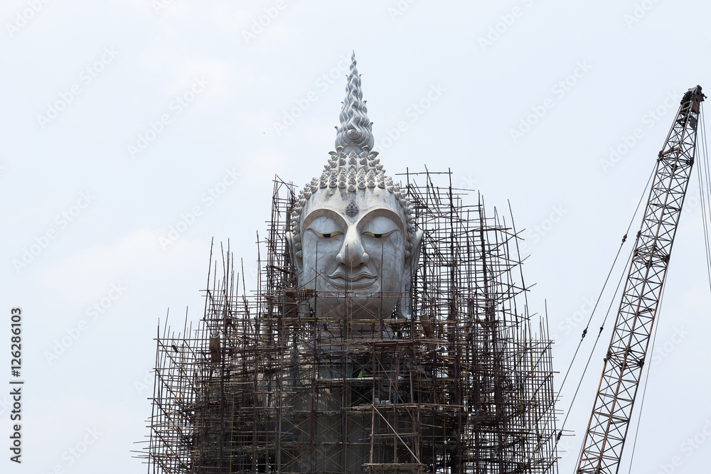 Fototapeta premium Restoration of Buddha with blue sky and white cloud, outdoor