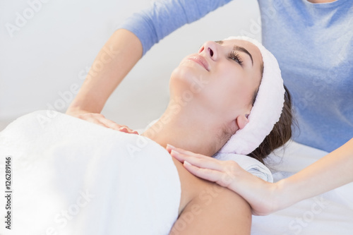Young woman enjoying facial massage at spa salon.Facial massage
